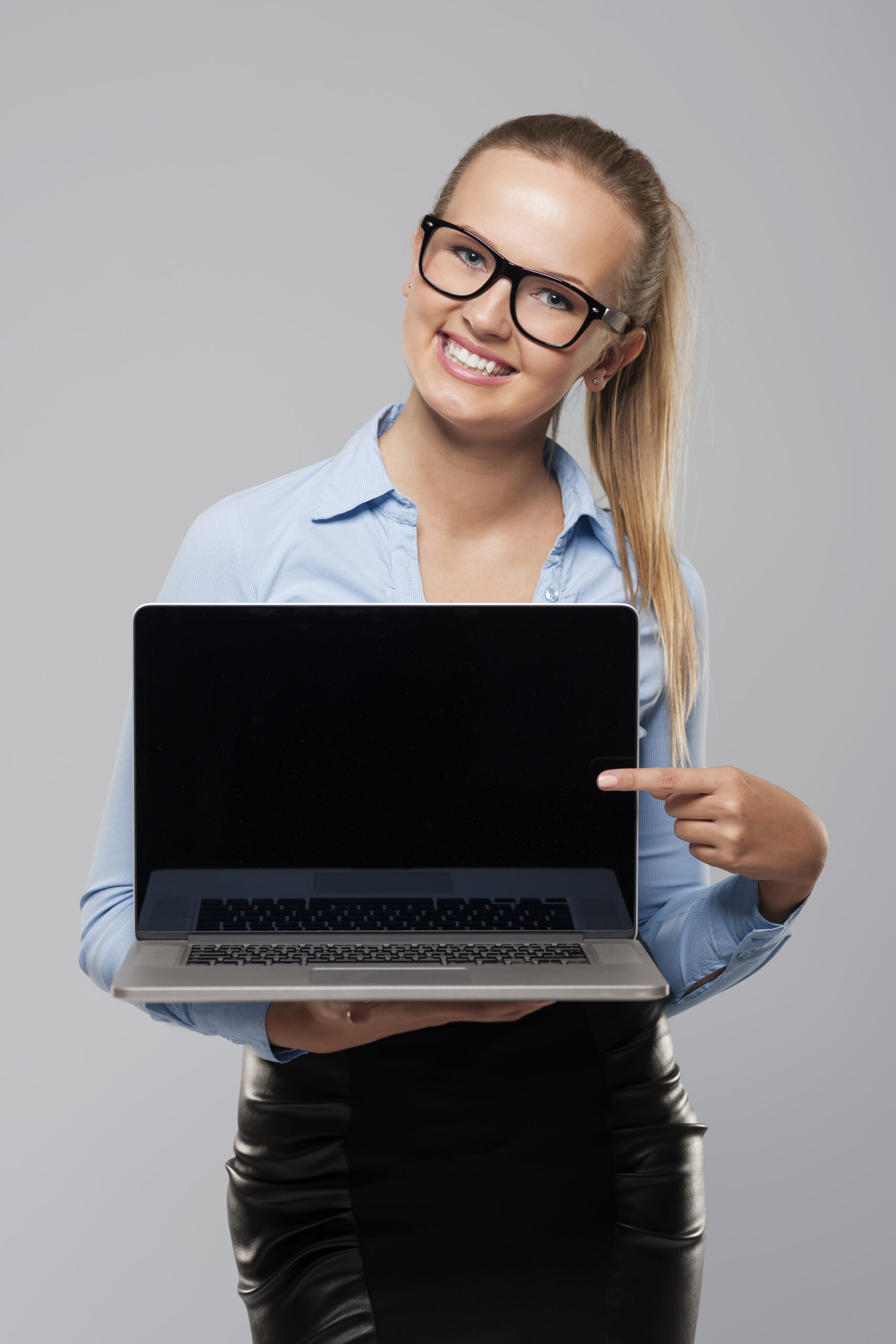 beautiful businesswoman showing on blank screen of laptop